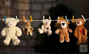 Five children toys hanging to dry on a clothesline with dark background